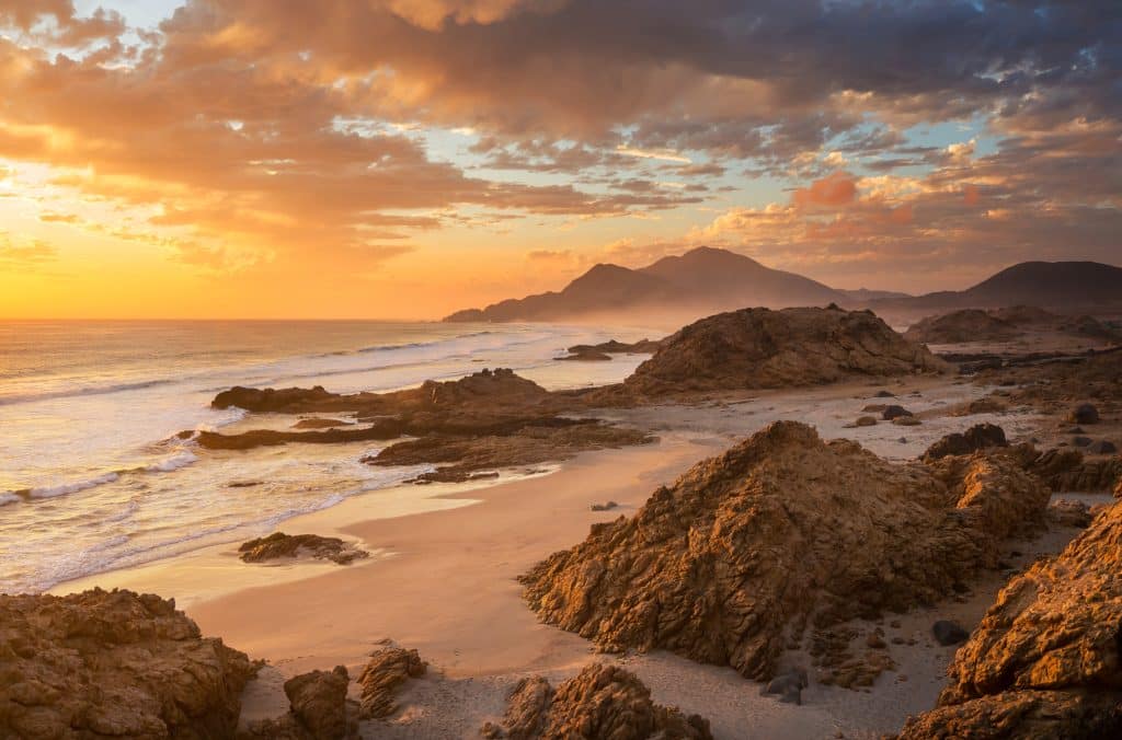 Rustgevend kustlandschap bij zonsondergang in Zuid-Afrika ter illustratie van professionele verslavingszorg en herstel.