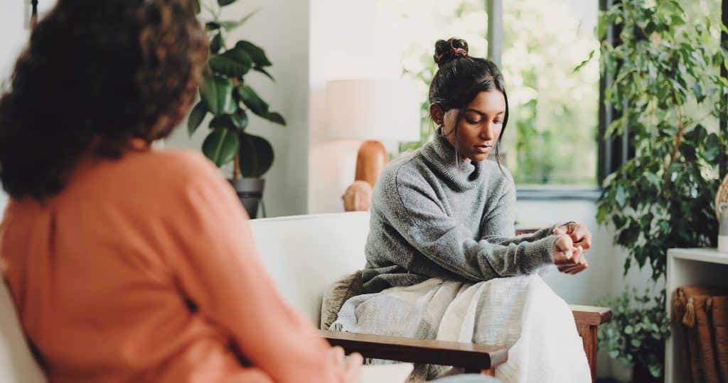 Jonge vrouw tijdens een individuele psychotherapeutiesessie in een rustige behandelruimte