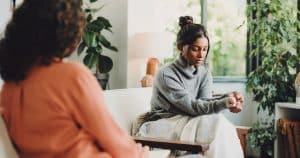 Jonge vrouw tijdens een individuele psychotherapeutiesessie in een rustige behandelruimte
